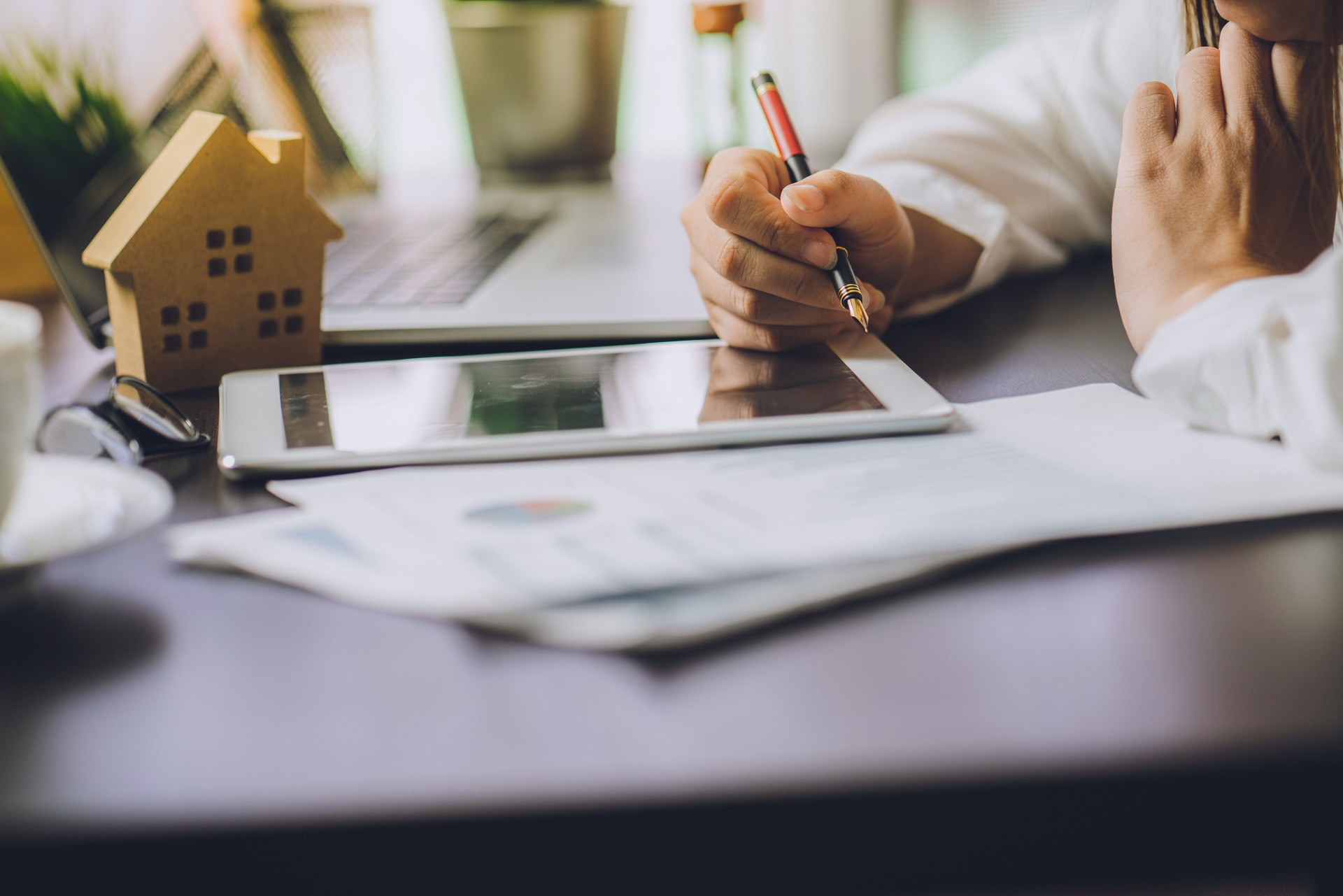 Hand of Business people calculating interest, taxes and profits to invest in real estate and home buying